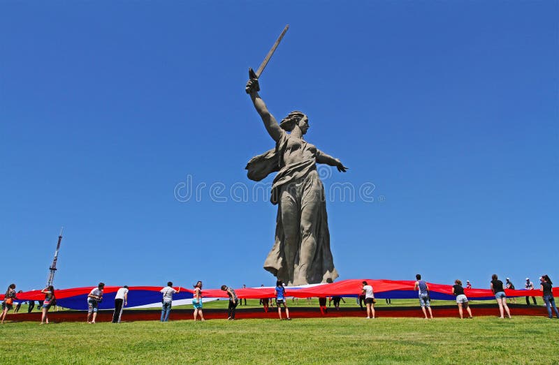 Os ativistas unfurl um grande russo que a bandeira no dia de Rússia no pé do monumento da pátria chama o monte de Mamaev em Volgo imagem de stock royalty free Os ativistas unfurl um grande russo que a bandeira no dia de Rússia no pé do monumento da pátria chama o monte de Mamaev em Volgo imagem de stock royalty free
