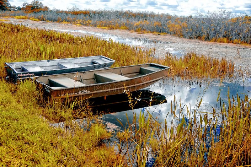 Os barcos em um rio suportam o outono nos pântanos