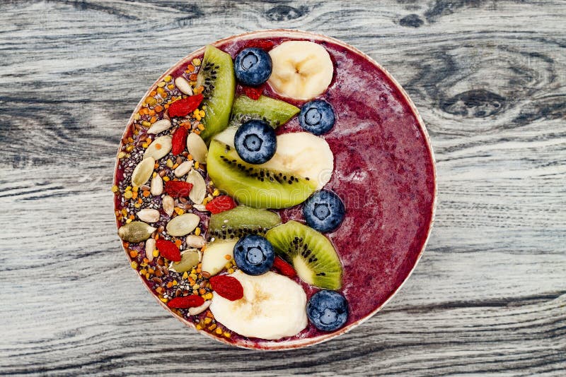 Os batidos dos superfoods do café da manhã de Acai rolam com sementes do chia, pólen da abelha, coberturas da baga do goji e frut fotografia de stock Os batidos dos superfoods do café da manhã de Acai rolam com sementes do chia, pólen da abelha, coberturas da baga do goji e frut fotografia de stock