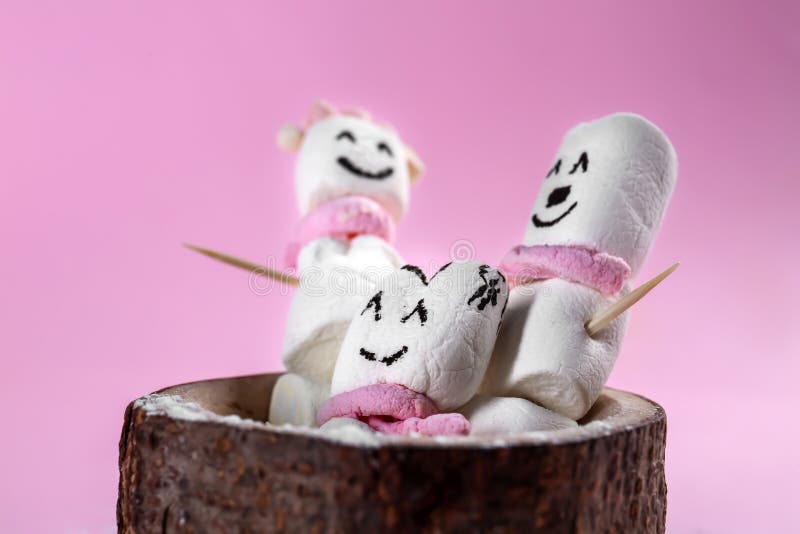 Os bonecos de neve bonitos fizeram do marshmallow saboroso no fundo da cor foto de stock Os bonecos de neve bonitos fizeram do marshmallow saboroso no fundo da cor foto de stock