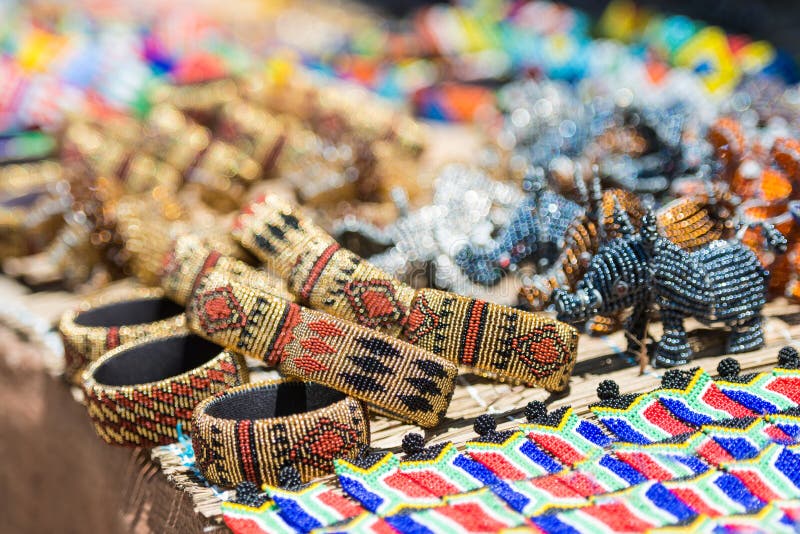 Os braceletes africanos coloridos perlam a arte com cores borradas brilhantes do rosa amarelo e da turquesa no fundo imagem de stock royalty free Os braceletes africanos coloridos perlam a arte com cores borradas brilhantes do rosa amarelo e da turquesa no fundo imagem de stock royalty free