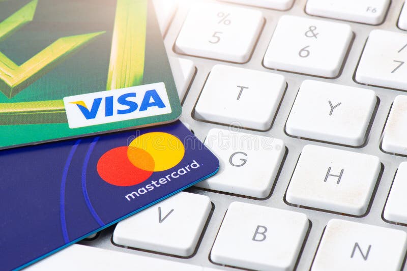 Os cartões de crédito do VISTO e do MASTERCARD apoiaram em um computador keyboar foto de stock Os cartões de crédito do VISTO e do MASTERCARD apoiaram em um computador keyboar foto de stock