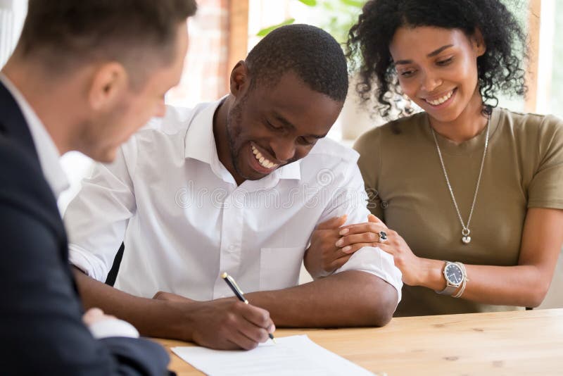 Os clientes africanos felizes dos pares da família assinam o contrato de seguro do empréstimo hipotecário fotos de stock Os clientes africanos felizes dos pares da família assinam o contrato de seguro do empréstimo hipotecário fotos de stock