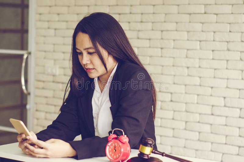 Os controles de leiloeiro fêmeas, os vencedores em linha do leilão da lista de verificação, com despertador retro e o martelo de fotos de stock royalty free Os controles de leiloeiro fêmeas, os vencedores em linha do leilão da lista de verificação, com despertador retro e o martelo de fotos de stock royalty free