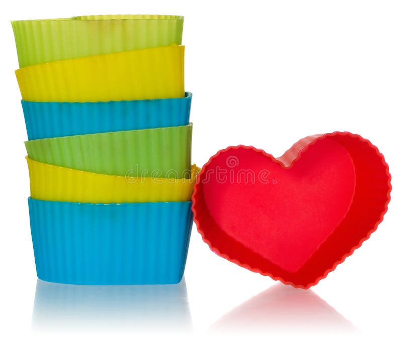 Os corações moldam para cookies em vermelho, amarelo, verde, azul Moldes do silicone arranjados em uma pilha foto de stock Os corações moldam para cookies em vermelho, amarelo, verde, azul Moldes do silicone arranjados em uma pilha foto de stock