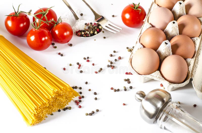 Os espaguetes encontram-se em um fundo branco, junto com tomates de cereja, uma colher e uma forquilha imagens de stock royalty free Os espaguetes encontram-se em um fundo branco, junto com tomates de cereja, uma colher e uma forquilha imagens de stock royalty free
