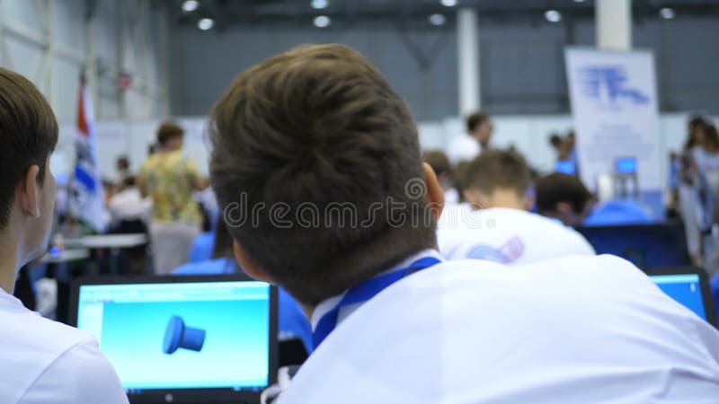 Os estudantes preparam um programa da apresentação e do modelo 3d para uma impressora 3d O terreno da escola onde os instrutores video estoque Os estudantes preparam um programa da apresentação e do modelo 3d para uma impressora 3d O terreno da escola onde os instrutores video estoque