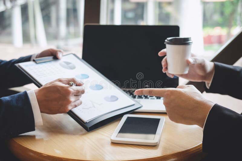 Os executivos da equipe discutem e analisando na reuni?o ao funcionamento de projeto de investimento e ? estrat?gia planejando da fotos de stock Os executivos da equipe discutem e analisando na reuni?o ao funcionamento de projeto de investimento e ? estrat?gia planejando da fotos de stock