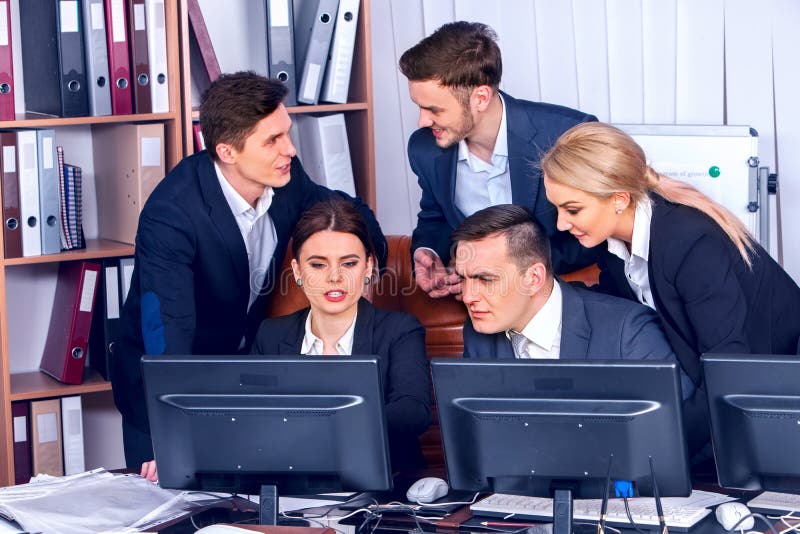 Os executivos team os povos que trabalham com papéis pelo monitor do computador fotos de stock Os executivos team os povos que trabalham com papéis pelo monitor do computador fotos de stock