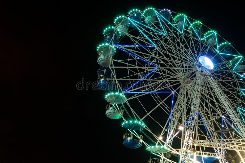 Os ferris de gerencio iluminados claros listrados coloridos rodam no movimento que move-se na noite imagens de stock royalty free Os ferris de gerencio iluminados claros listrados coloridos rodam no movimento que move-se na noite imagens de stock royalty free