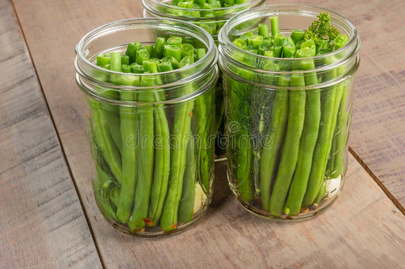 Os frascos de gren os feijões prontos para preservar imagens de stock Os frascos de gren os feijões prontos para preservar imagens de stock