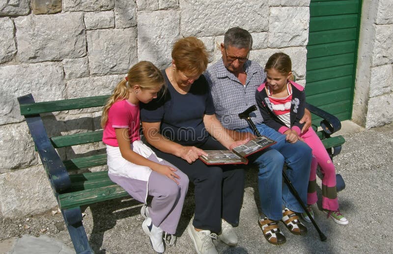 Os Grandparents com netos prestam atenção a uma foto