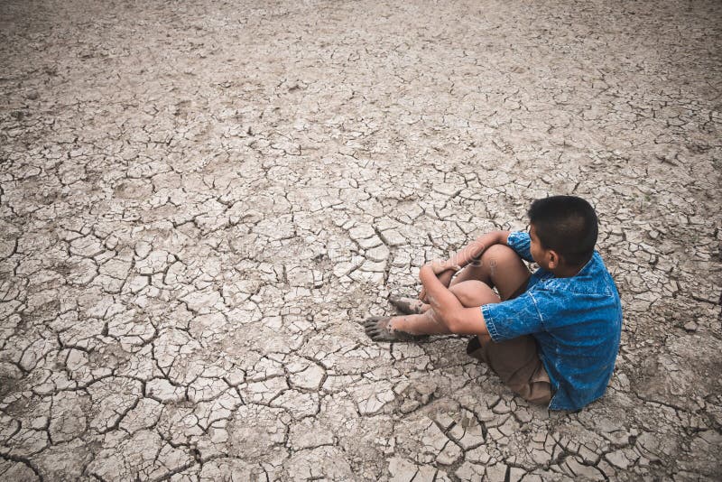 Os homens na terra racharam seco devido à seca foto de stock Os homens na terra racharam seco devido à seca foto de stock