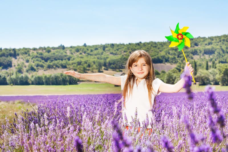 Os jogos bonitos da menina com o girândola na alfazema colocam fotografia de stock royalty free Os jogos bonitos da menina com o girândola na alfazema colocam fotografia de stock royalty free