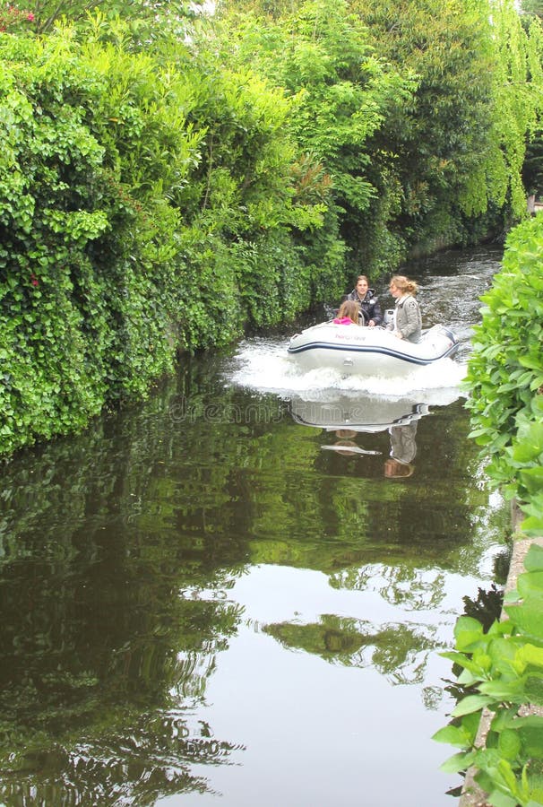 Jovens navegam num barco a motor, Loosdrecht, Países Baixos imagens de stock