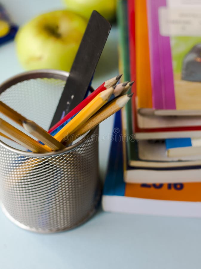 Os livros, os lápis, e as maçãs na tabela fotos de stock royalty free