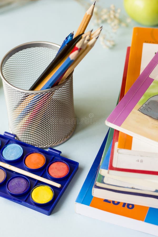 Os livros, os lápis, e as maçãs na tabela fotos de stock