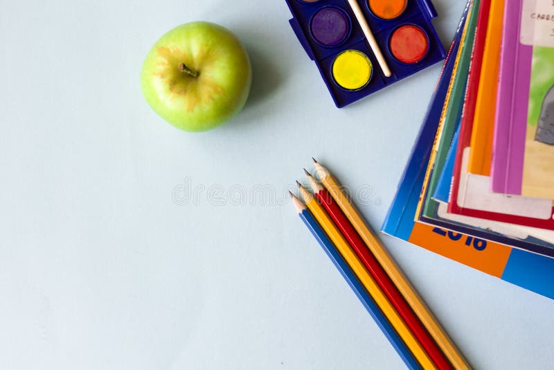 Os livros, os lápis, e as maçãs na tabela fotografia de stock royalty free