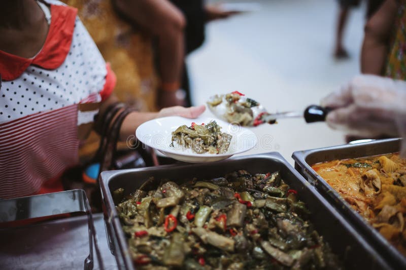 Os mendigos recebem comida quente e deliciosa das mãos do doador: o conceito de mendigos alimentares