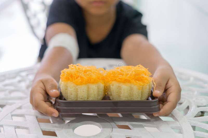 Os meninos nas mãos feridas guardam bolos de uma linha da gema do ouro foto de stock Os meninos nas mãos feridas guardam bolos de uma linha da gema do ouro foto de stock