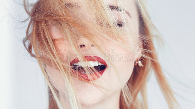 Young blonde woman portrait. Hair blowing in wind. Eyes closed mouth open. Freedom solitude relaxation emotions. Young blonde woman portrait. Hair blowing in wind. Eyes closed mouth open. Freedom solitude relaxation emotions.