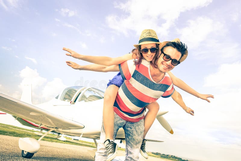 Os pares felizes do moderno no amor na lua de mel do curso do avião tropeçam
