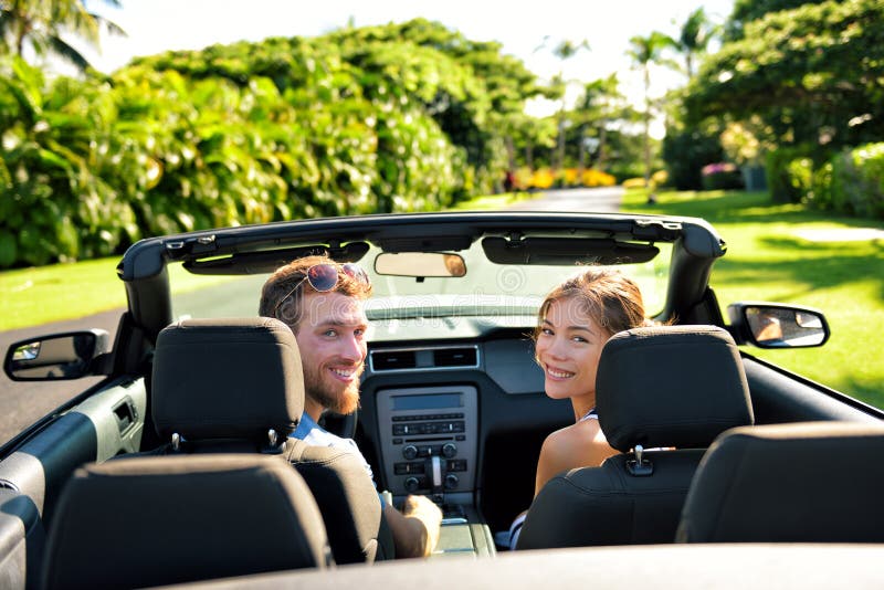 Os pares felizes no carro na viagem por estrada do verão viajam