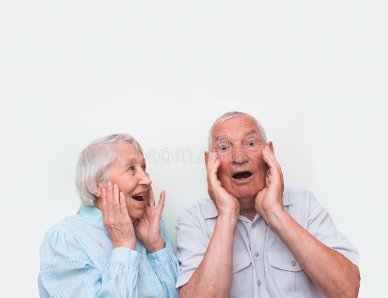 Os pares idosos surpreendidos levantando ambas as mãos fotos de stock Os pares idosos surpreendidos levantando ambas as mãos fotos de stock