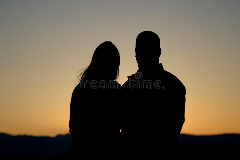 Os pares mostram em silhueta no por do sol foto de stock Os pares mostram em silhueta no por do sol foto de stock