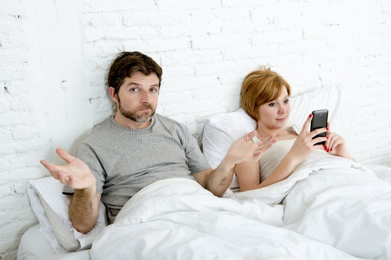 Os pares no marido da cama frustraram a virada e insatisfeito quando sua esposa do viciado do Internet usar o telefone celular