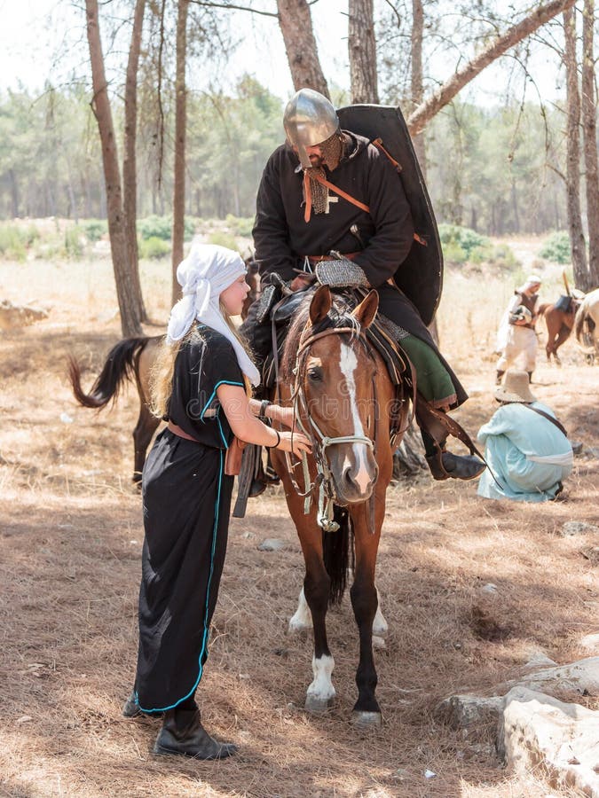 Os participantes na reconstrução dos chifres da batalha em 1187 uma de Hattin sentam-se em um cavalo da batalha, e segundo guarda fotografia de stock Os participantes na reconstrução dos chifres da batalha em 1187 uma de Hattin sentam-se em um cavalo da batalha, e segundo guarda fotografia de stock
