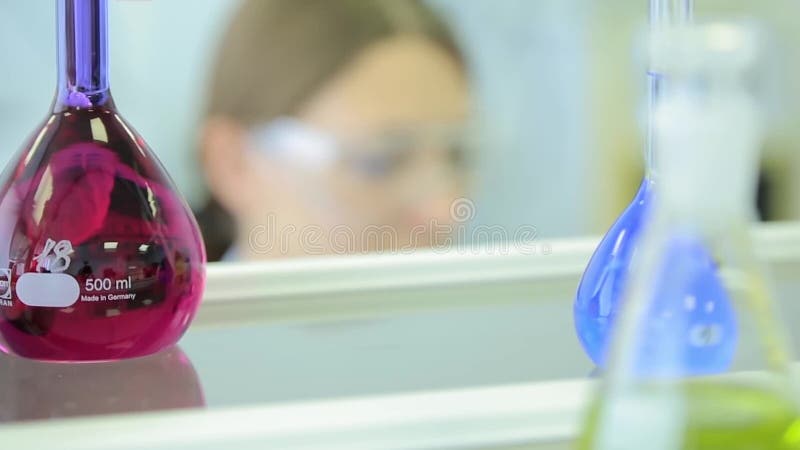 Os pesquisadores fêmeas que realizam a pesquisa junto em uma cor do centro de pesquisa do laboratório de química tonificaram a im
