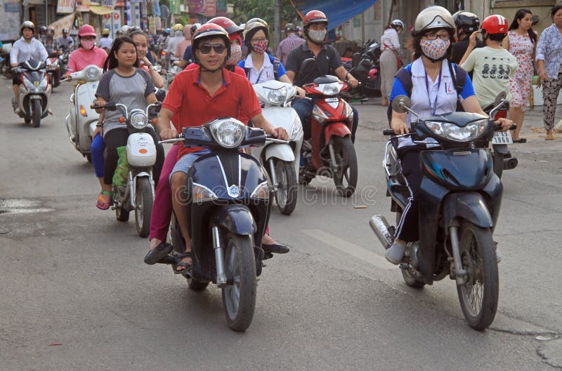 Os povos estão montando em motocicletas em Hanoi, Vietname fotografia de stock royalty free Os povos estão montando em motocicletas em Hanoi, Vietname fotografia de stock royalty free