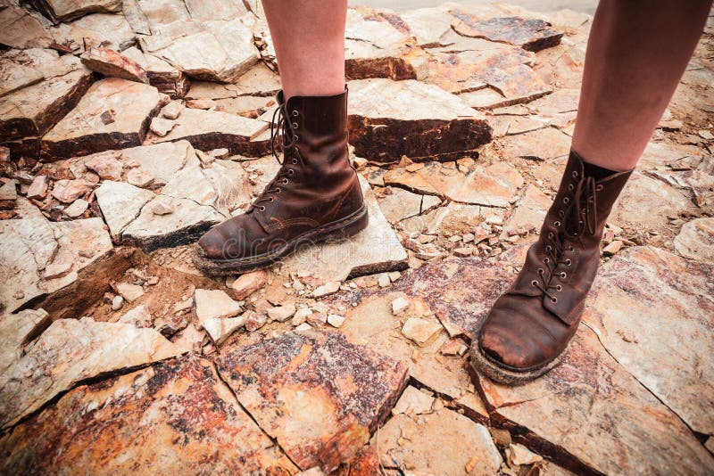 Os pés de uma jovem mulher que está em algumas rochas fotografia de stock Os pés de uma jovem mulher que está em algumas rochas fotografia de stock