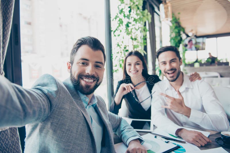 Os sócios comerciais felizes dos amigos estão fazendo a foto do selfie, sentando-se fotos de stock royalty free Os sócios comerciais felizes dos amigos estão fazendo a foto do selfie, sentando-se fotos de stock royalty free