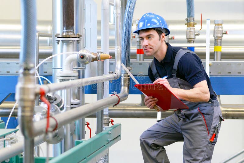 Os trabalhadores industriais inspecionam a tecnologia de uma planta para o functio fotografia de stock Os trabalhadores industriais inspecionam a tecnologia de uma planta para o functio fotografia de stock
