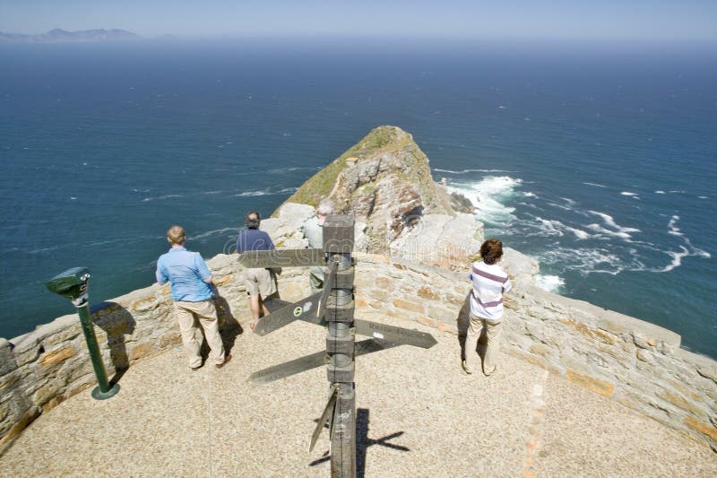 Os turistas que olham a vista panorâmica do ponto do cabo, cabo da boa esperança, fora de Cape Town, África do Sul mostram a aflu foto de stock Os turistas que olham a vista panorâmica do ponto do cabo, cabo da boa esperança, fora de Cape Town, África do Sul mostram a aflu foto de stock