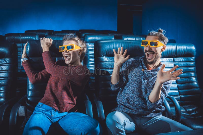 Os vidros do indivíduo e da menina 3d são preocupados muito ao olhar um filme imagens de stock Os vidros do indivíduo e da menina 3d são preocupados muito ao olhar um filme imagens de stock