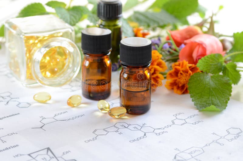 Óleos essenciais com ervas e suplemento em folha de ciência imagem de stock royalty free