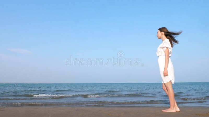 Osamotniony kobiety odprowadzenie wzdłuż plaży w biel sukni