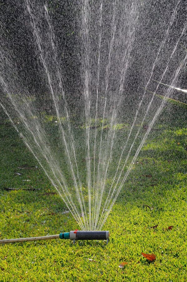 Oscillating garden sprinkler on Mediterranean grass, Costa del Sol, Andalucia, Spain, Western Europe. Oscillating garden sprinkler on Mediterranean grass, Costa del Sol, Andalucia, Spain, Western Europe.