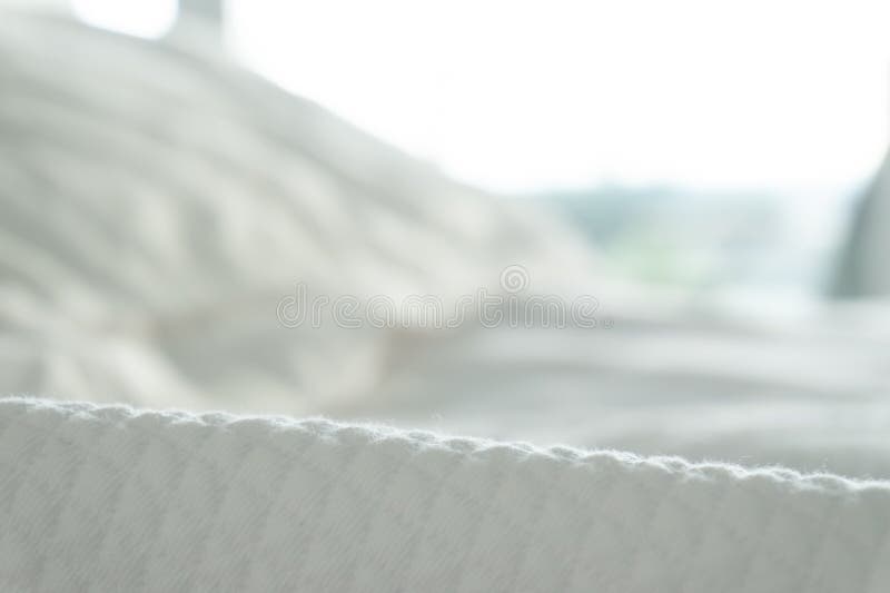 Oskarp bakgrund med mjuka vita linnar och det vita slutet f? r dillandebomullsfilt upp F? rgrika stenar p? en strand arkivfoto