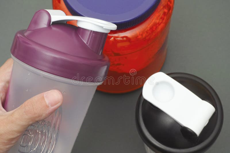 Osoba chwyty opróżniają potrząsacza w jego ręce nad proteina słój obraz stock Osoba chwyty opróżniają potrząsacza w jego ręce nad proteina słój obraz stock