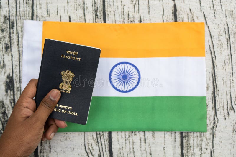 Osoby mienia Indiański paszport z ręką na Indiańskiej fladze jako tło zdjęcia royalty free Osoby mienia Indiański paszport z ręką na Indiańskiej fladze jako tło zdjęcia royalty free