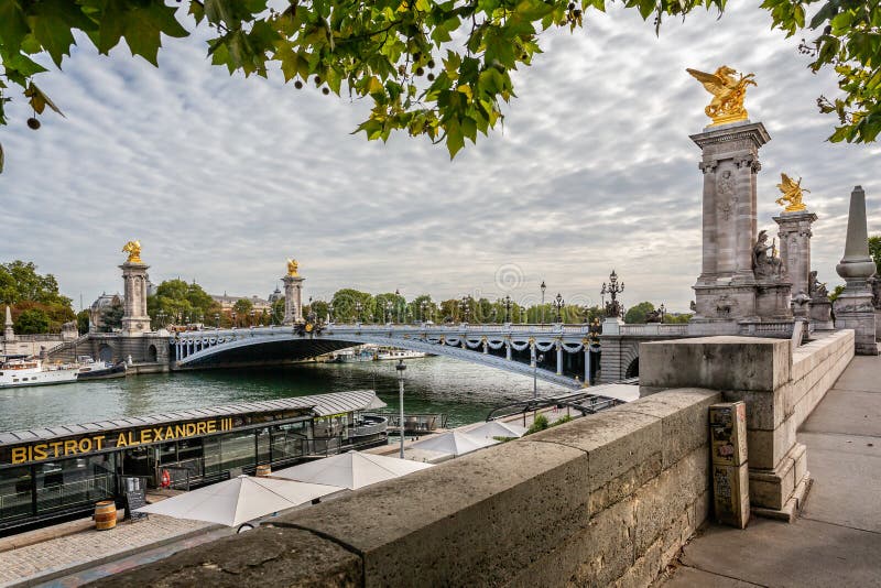 Osservi lo sguardo attraverso il ponte decorato di Alessandro III verso il grande Palais a Parigi immagine stock Osservi lo sguardo attraverso il ponte decorato di Alessandro III verso il grande Palais a Parigi immagine stock