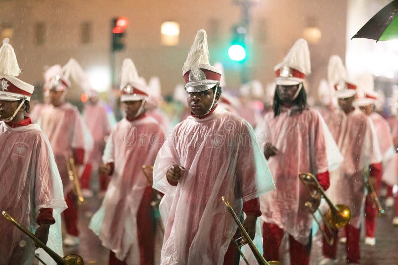 New Orleans, Louisiana, USA - February 23, 2019: Mardi Gras Parade, Marching Band under heavy rain performing at the Mardi Gras parade. New Orleans, Louisiana, USA - February 23, 2019: Mardi Gras Parade, Marching Band under heavy rain performing at the Mardi Gras parade