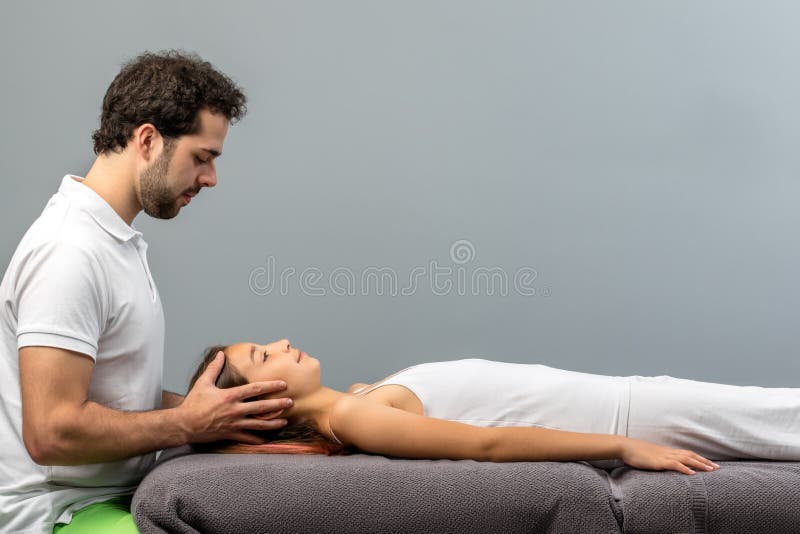 Osteopat som gör kranie- terapi på barn arkivfoto Osteopat som gör kranie- terapi på barn arkivfoto