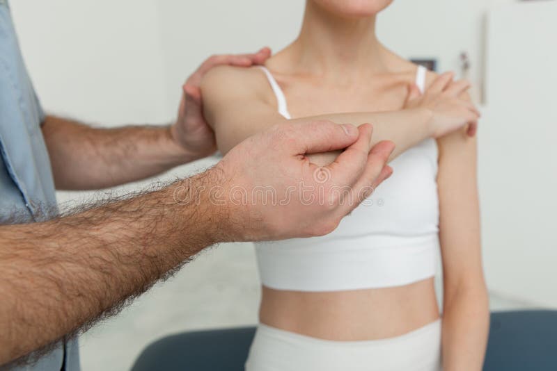 Osteopathic arm or shoulder massage. Elbow pain relief. Chiropractic treatment. Doctor doing shoulder blade therapy