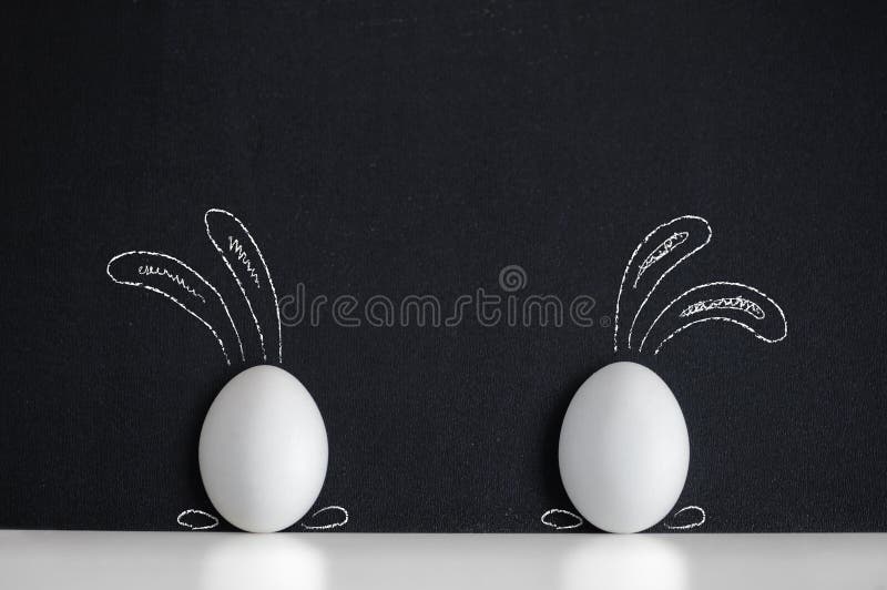 Ostereier gemalt wie Kaninchen auf dem schwarzen Hintergrund
