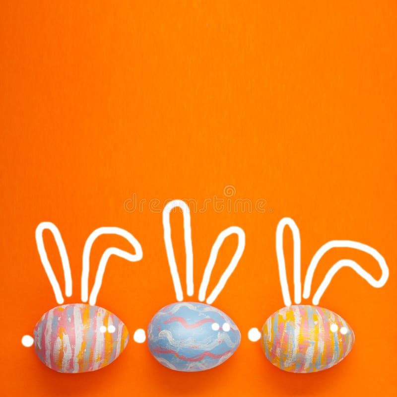 Ostern färbte Eier auf einem orangebackground, mit den gemalten Haseohren Hintergrund für eine Postkarte, Ostern-Konzept, Raum fü stockfotos Ostern färbte Eier auf einem orangebackground, mit den gemalten Haseohren Hintergrund für eine Postkarte, Ostern-Konzept, Raum fü stockfotos